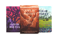 Three 'Field Notes' notebooks with different designs on a white background